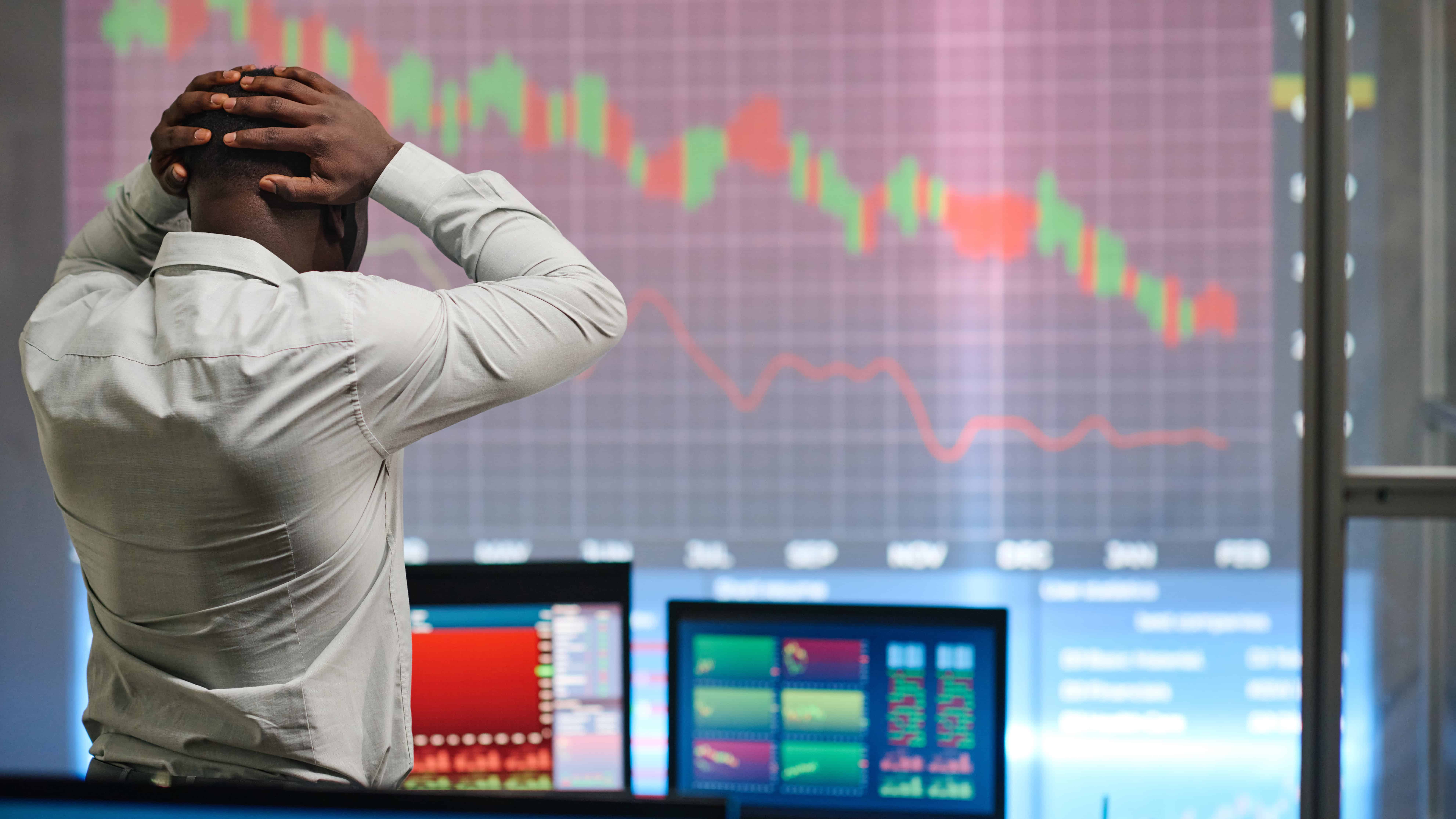 Man looking at graph decreasing and feeling disappointment.