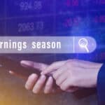 Hand touching smartphone with earnings season written in a search bubble above.
