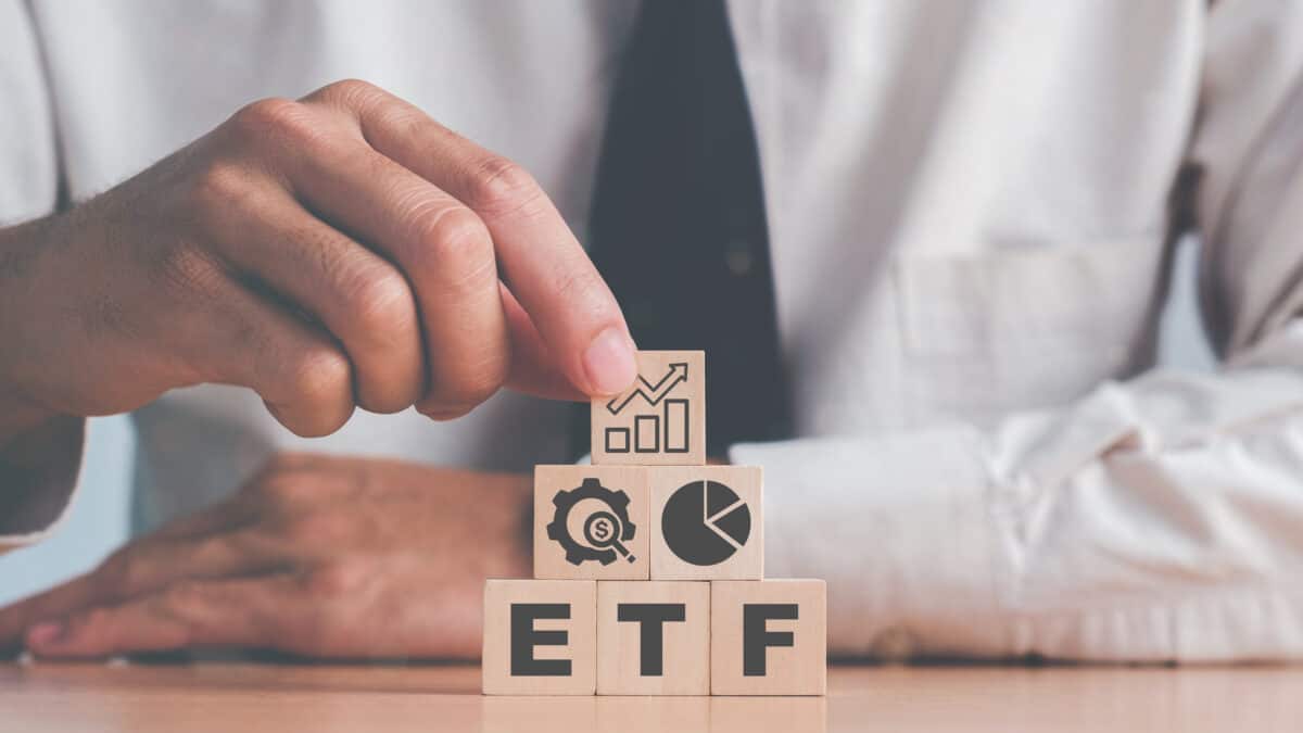 ETF on wooden blocks, with finance images on top.