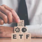 ETF on wooden blocks, with finance images on top.