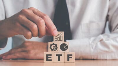 ETF on wooden blocks, with finance images on top.