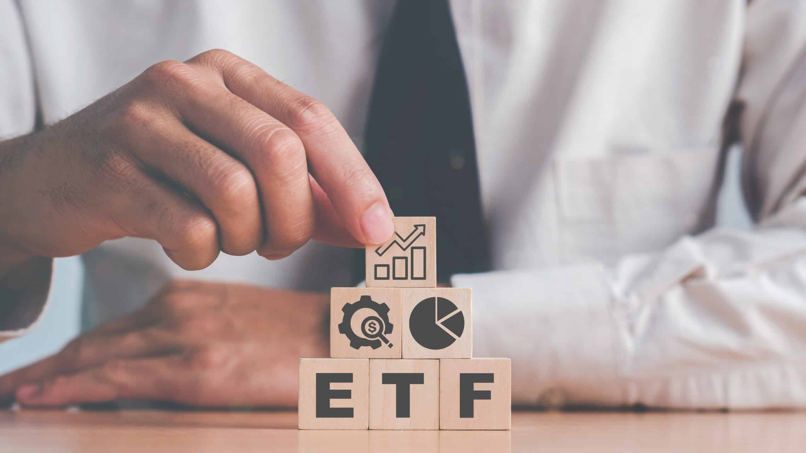 ETF on wooden blocks, with finance images on top.