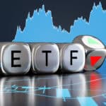 Silver metallic dice showing the alphabets ETF and an up and down arrow on backgrounds of stock charts.