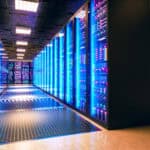 Server room corridor with illuminated racks.
