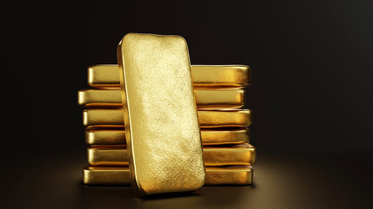 Gold bullion leaning on a stack of gold ingots.