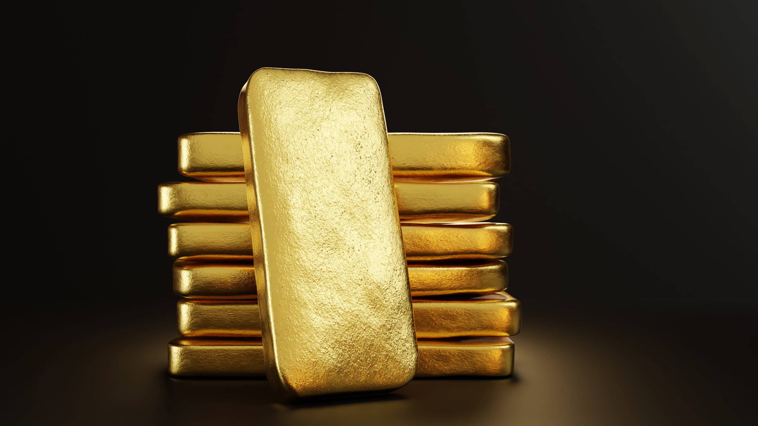 Gold bullion leaning on a stack of gold ingots.