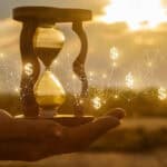 Hourglass in a hand with white lines and dollar signs.