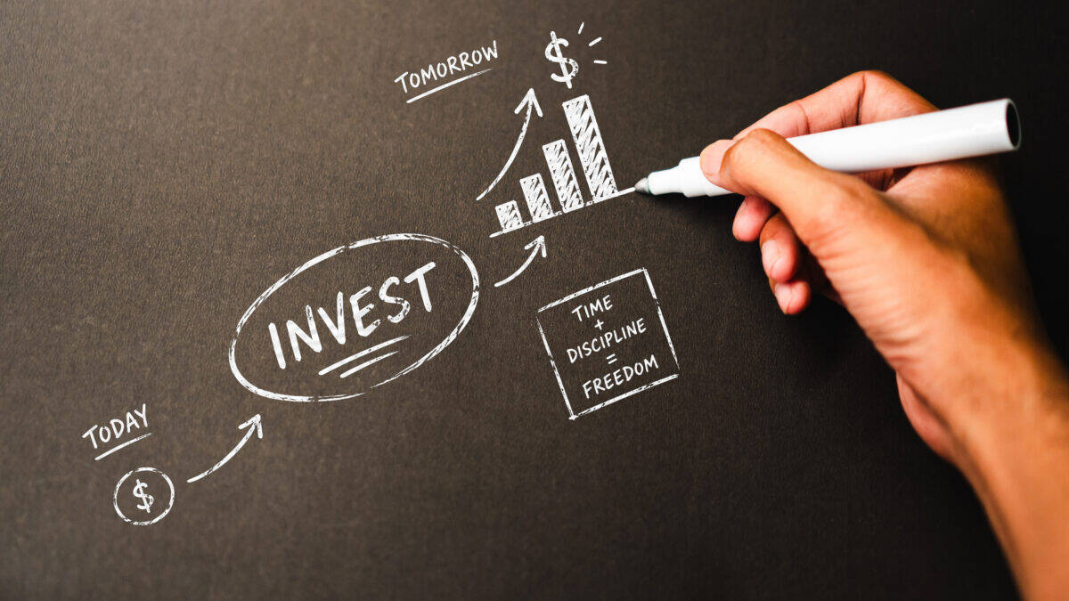 Hand sketching investment growth concept chart with chalk on blackboard.