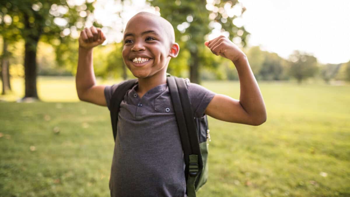 Smiling kid flexing his muscles.