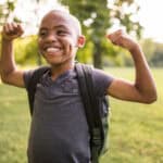 Smiling kid flexing his muscles.