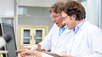 Two scientists analysing results on a computer screen.