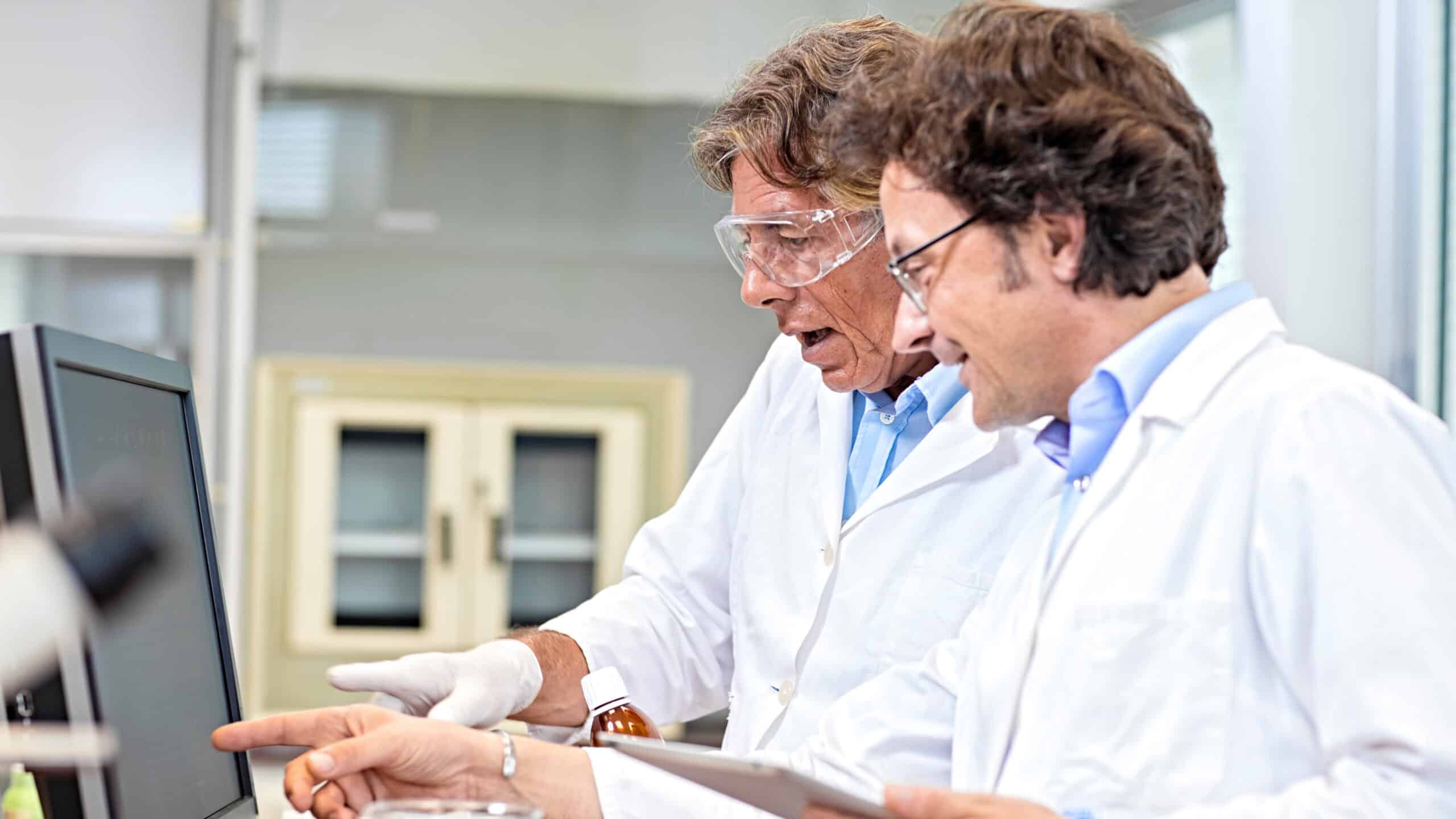 Two scientists analysing results on a computer screen.