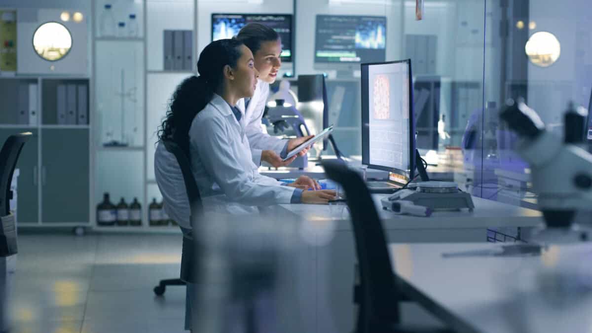 Two health professionals working on a computer.