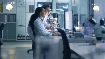 Two health professionals working on a computer.