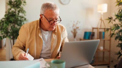 Man looking down and trying to work his laptop.