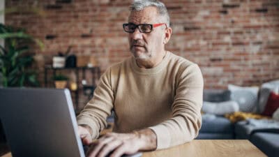 Man working on a laptop from home.
