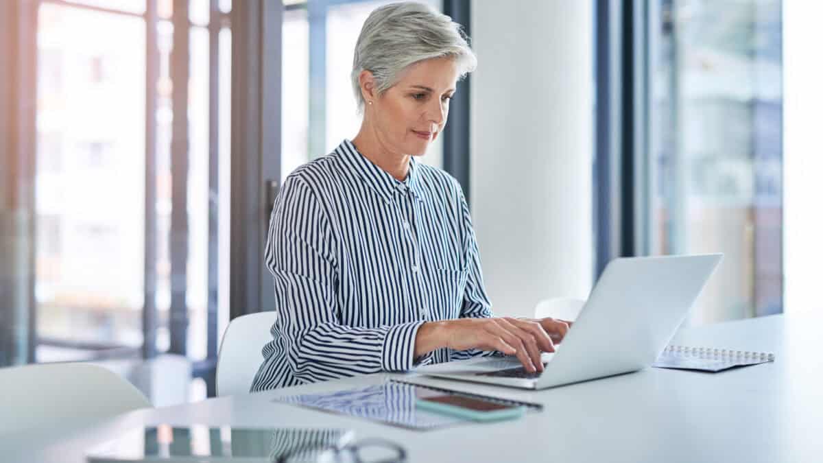 Middle-aged woman working on a laptop.