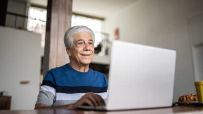 Pensioner looking at his laptop.