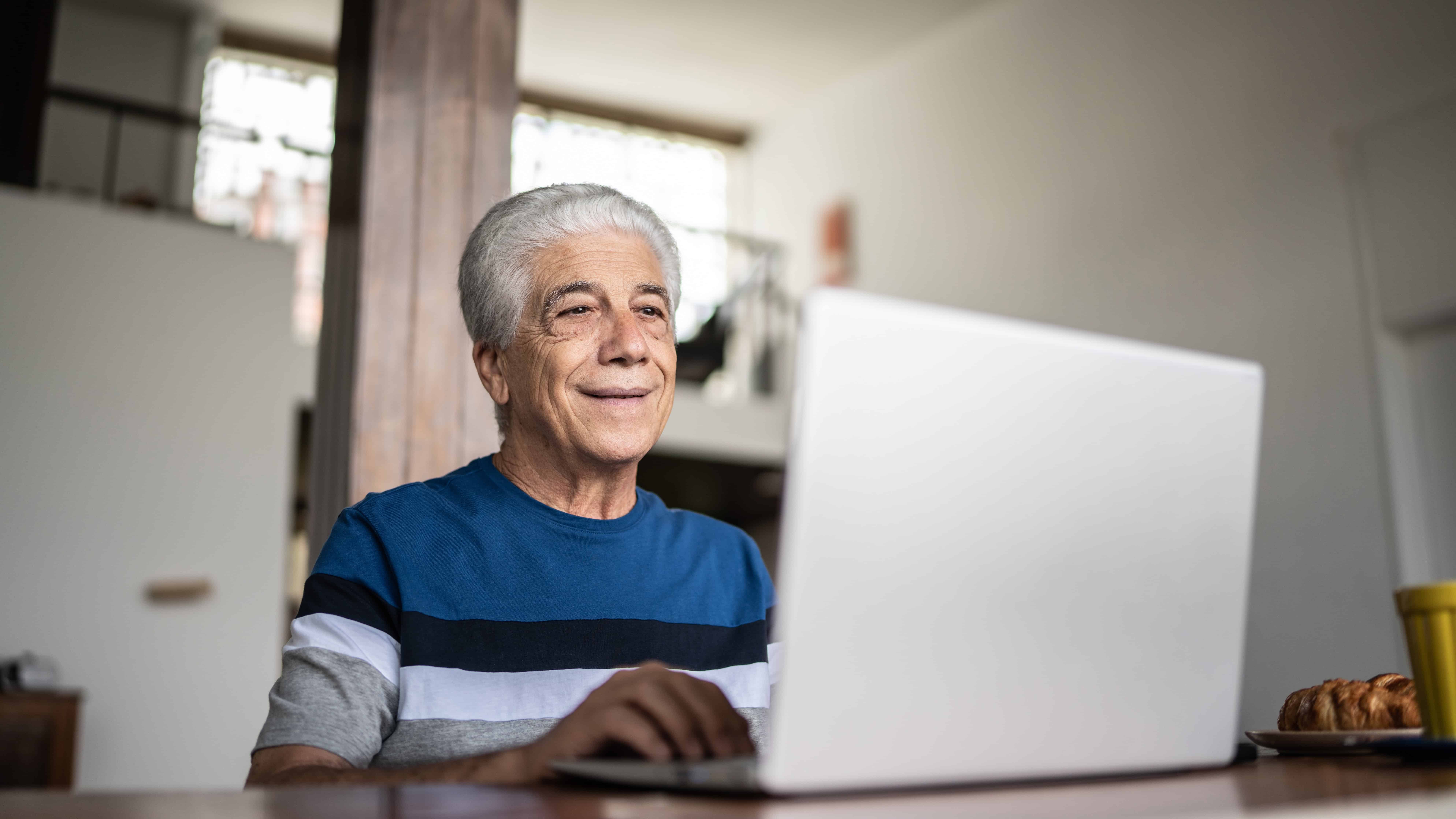 Pensioner looking at his laptop.