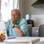 Man looking at his laptop and pondering data.