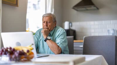 Man looking at his laptop and pondering data.