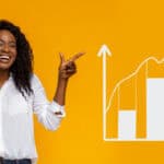 Smiling woman pointing at rising graph.