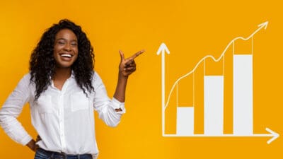 Smiling woman pointing at rising graph.