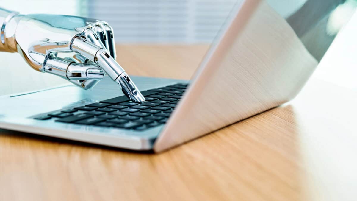 Robot's hand typing on keyboard.
