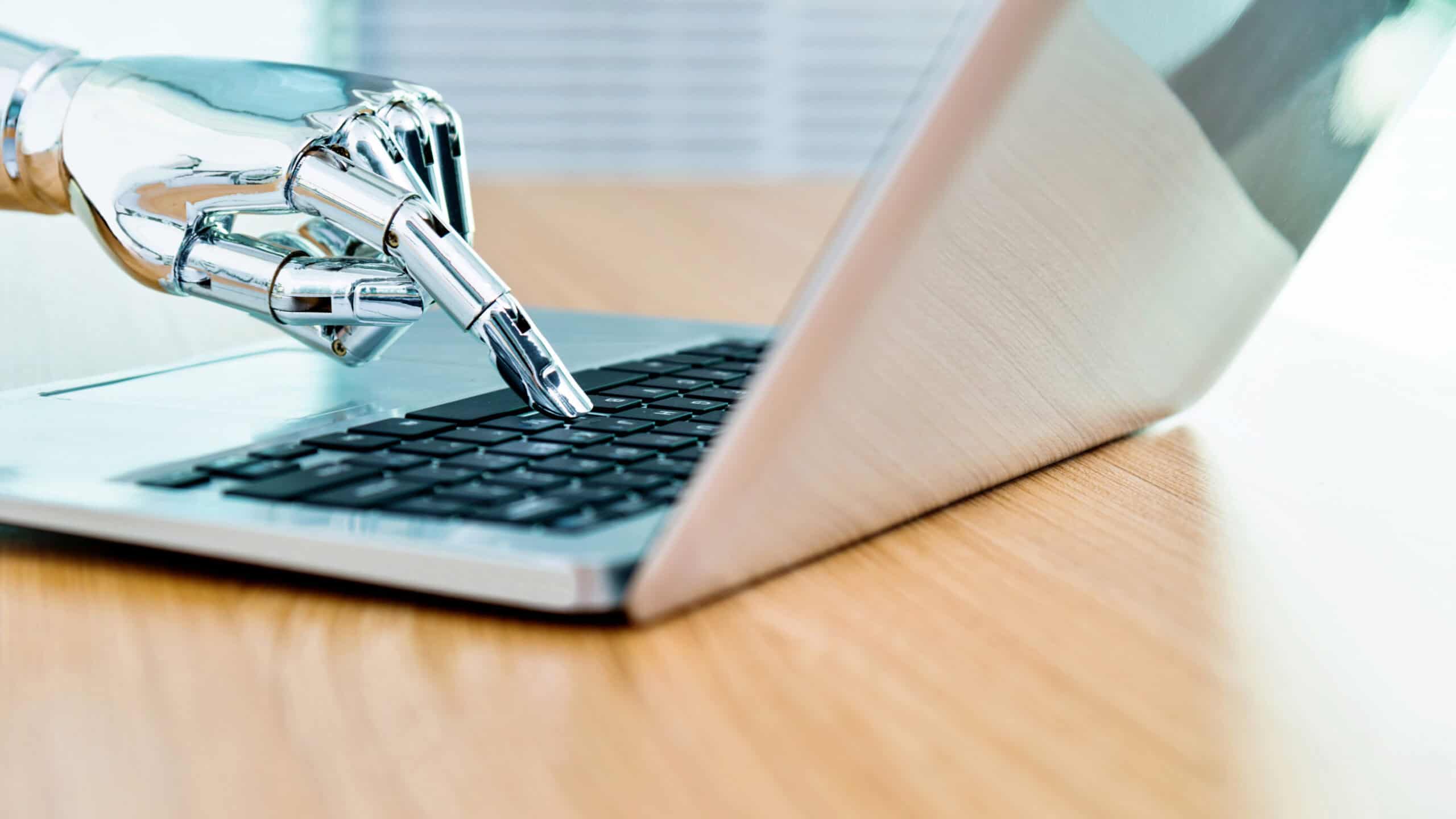 Robot's hand typing on keyboard.