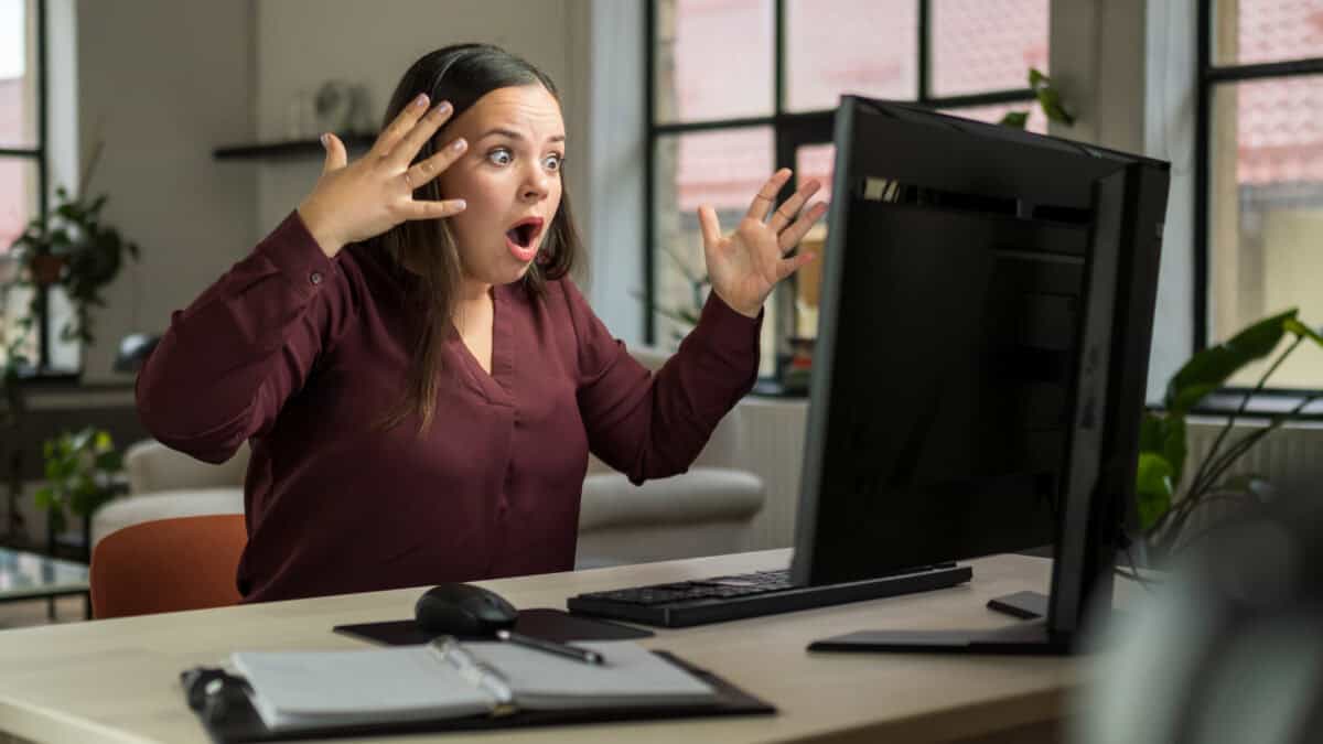 Shocked woman reacts to news on her computer.