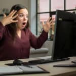 Shocked woman reacts to news on her computer.