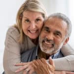 Wife hugging husband, with both smiling.