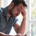 Worried man watching his smartphone.