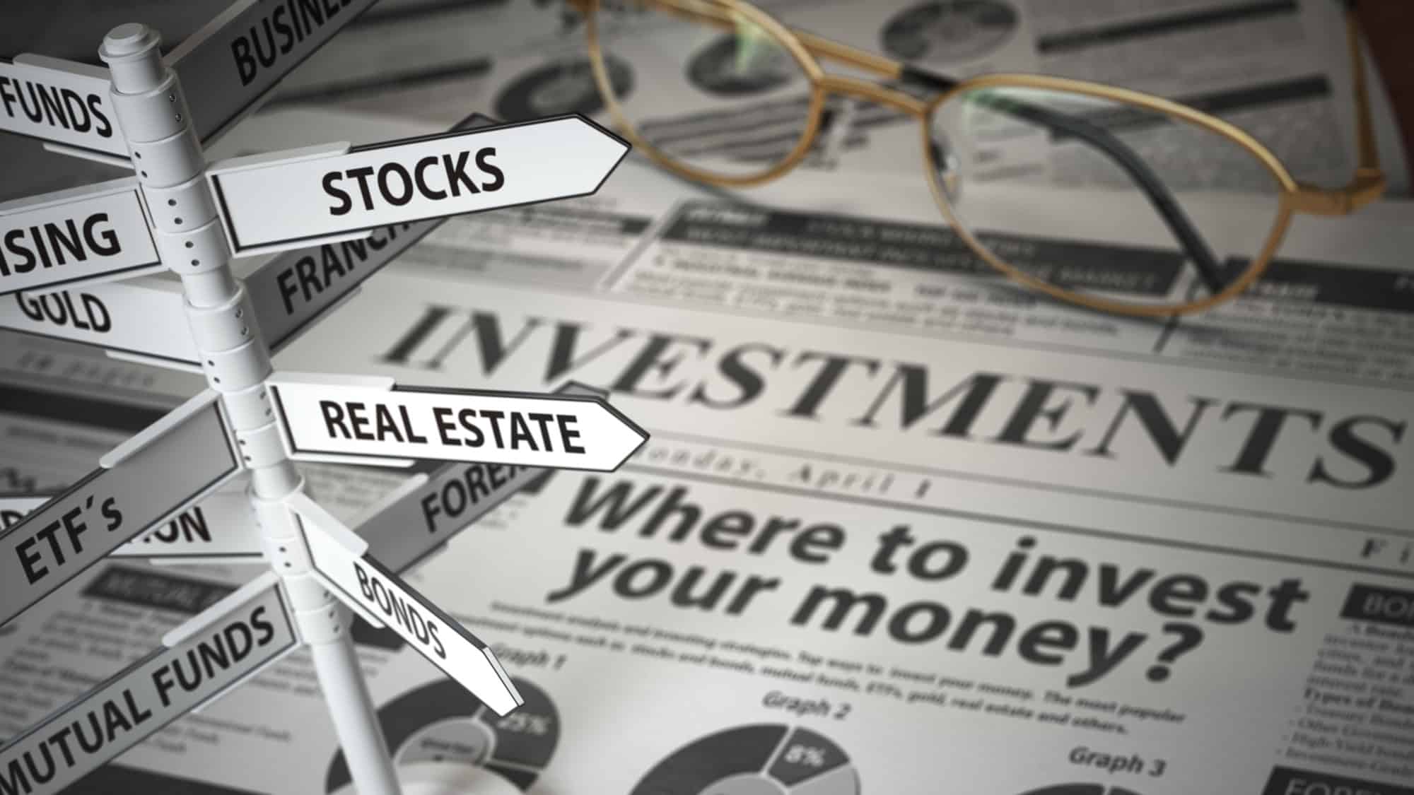 Signs of asset classes on a newspaper which says 'Where to invest your money?'.