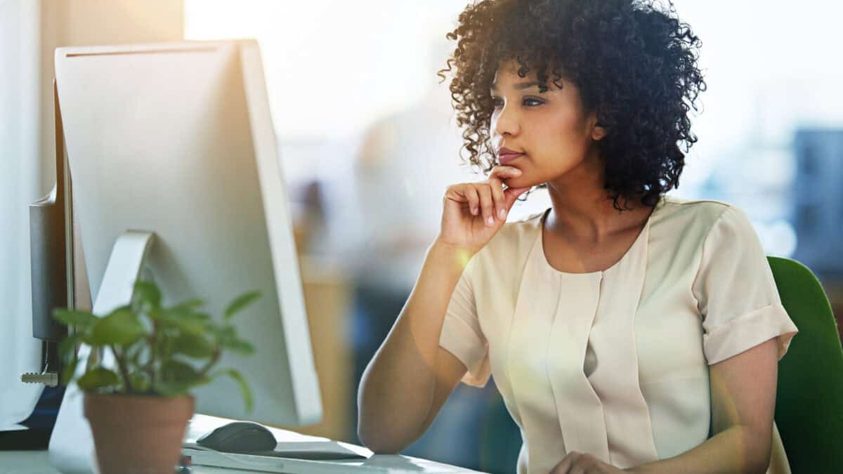 Woman looking at her computer and pondering something.