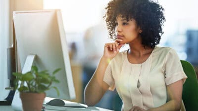 Woman looking at her computer and pondering something.