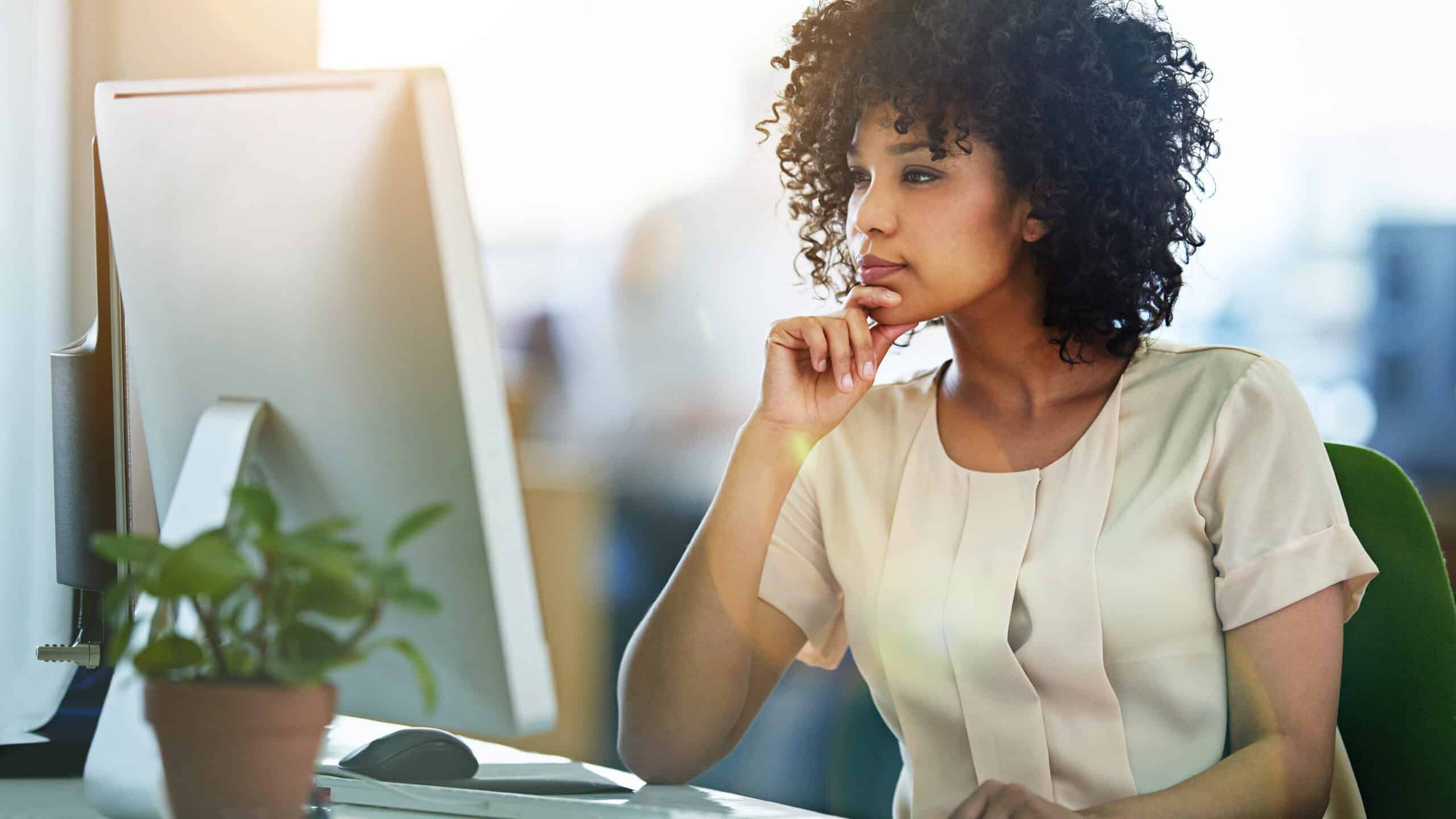 Woman looking at her computer and pondering something.