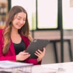 Happy female accountant looking at her tablet.