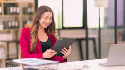 Happy female accountant looking at her tablet.