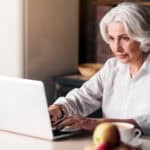 Elder woman typing on her laptop.