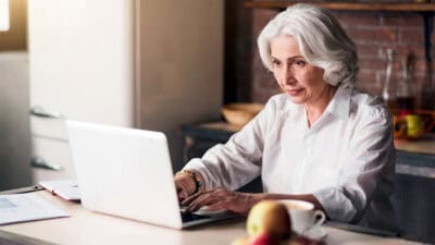 Elder woman typing on her laptop.