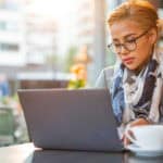 Woman working on her laptop at a café.