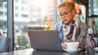 Woman working on her laptop at a café.