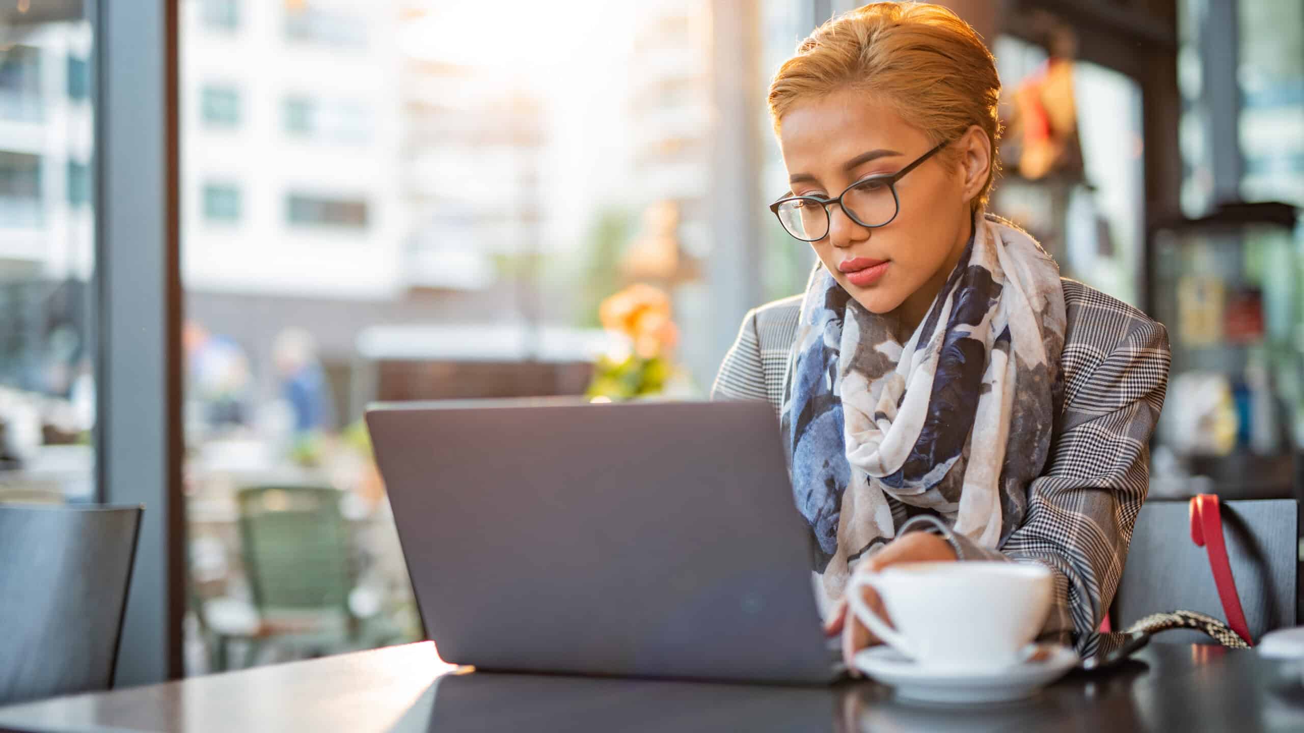 Woman working on her laptop at a café.