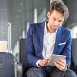 Man using his device in an airport.