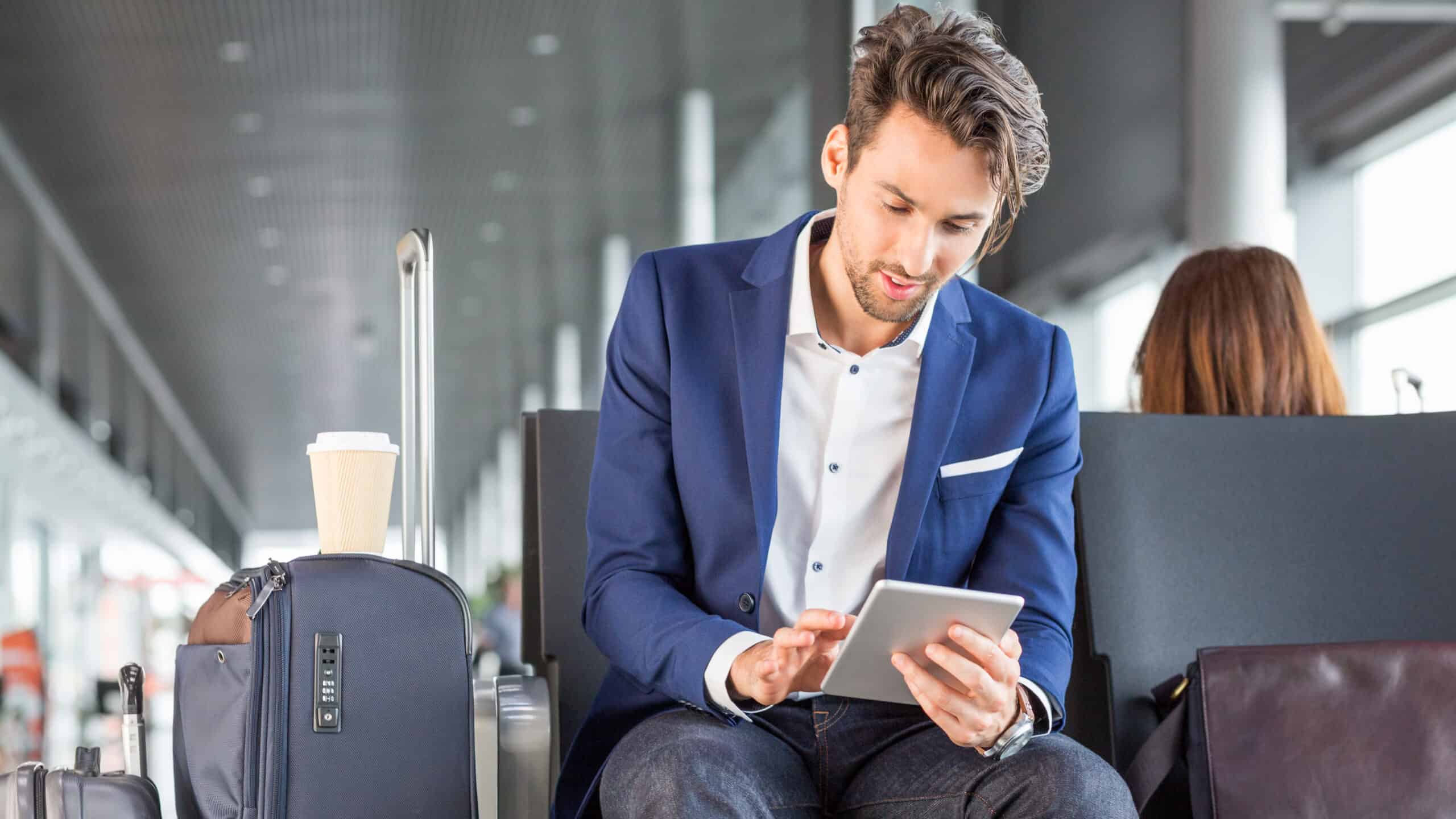Man using his device in an airport.