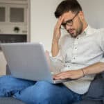 Worried and anxious man using his laptop.