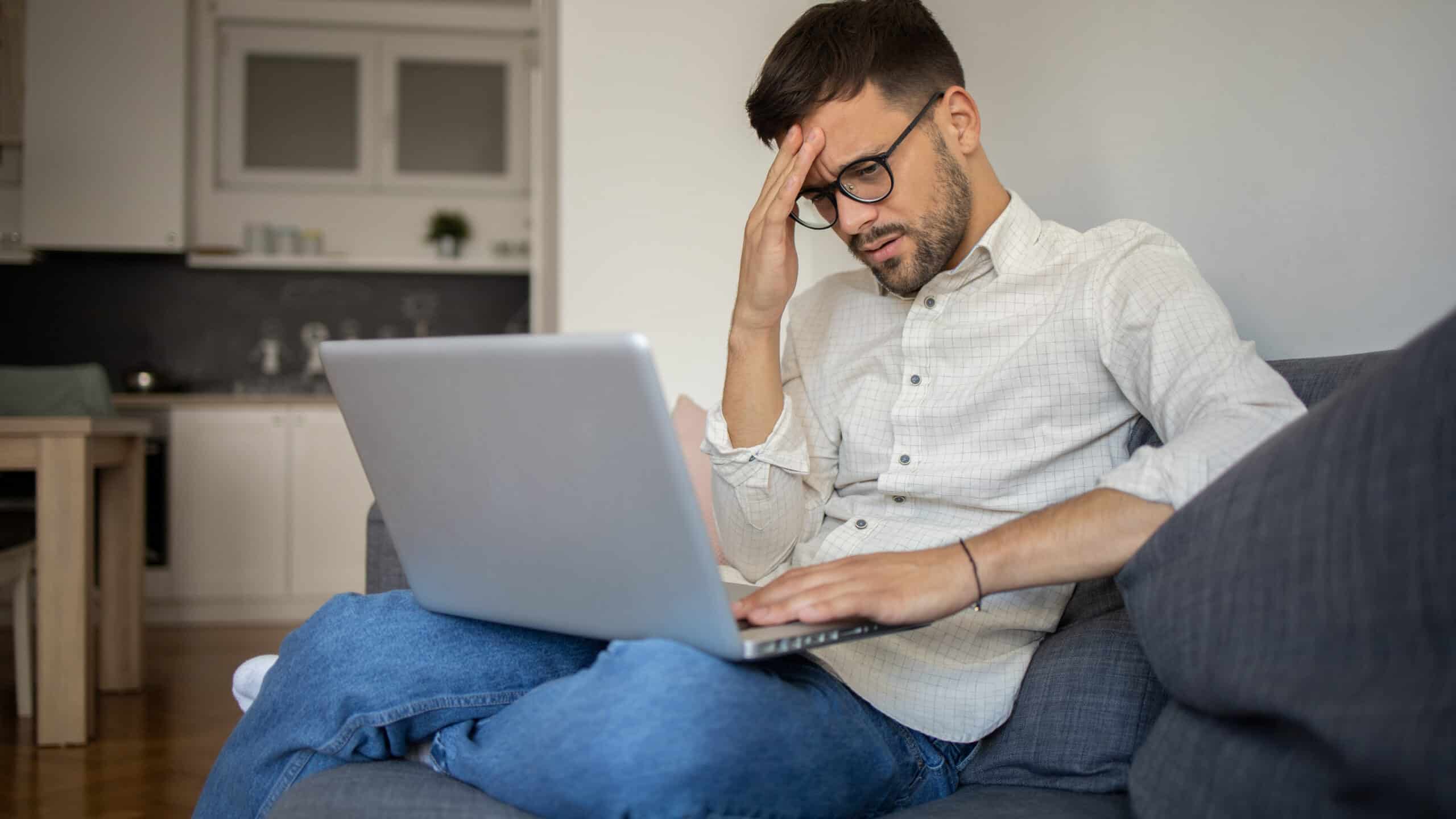 Worried and anxious man using his laptop.