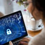 Woman on laptop with screen showing lock with numbers in the background.