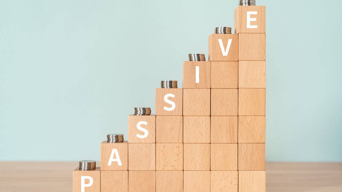 Passive written in white on an increasing pile of wooden blocks with coins on them.